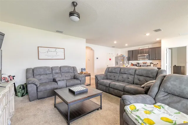 a living room with furniture and kitchen view
