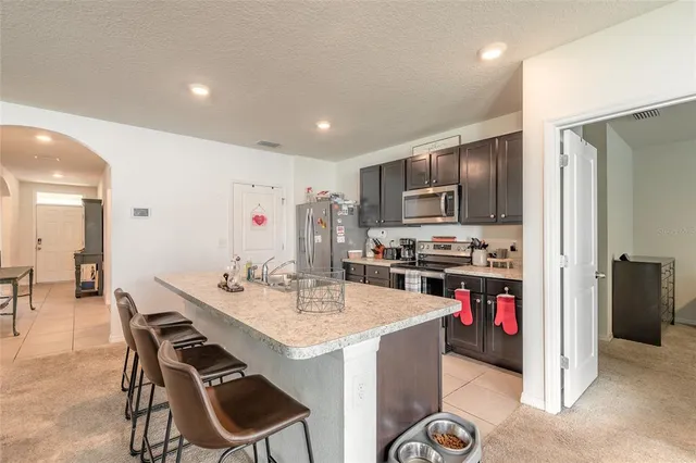 a kitchen with a dining table cabinets appliances and wooden floor