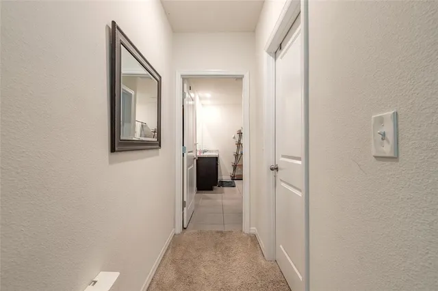 a view of a hallway with a livingroom and a bathroom with sink