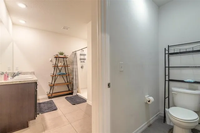 a bathroom with a granite countertop sink a toilet and shower