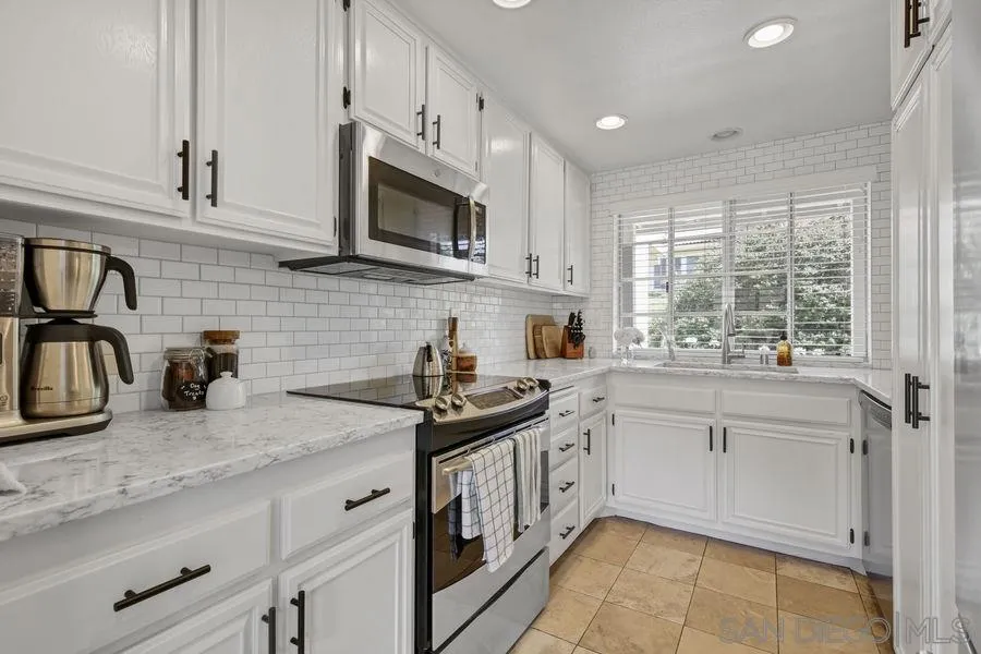 1758 Edgefield Lane Encinitas, CA 92024 - Photo 1 of 25 a kitchen with stainless steel appliances granite countertop white cabinets a sink and a stove