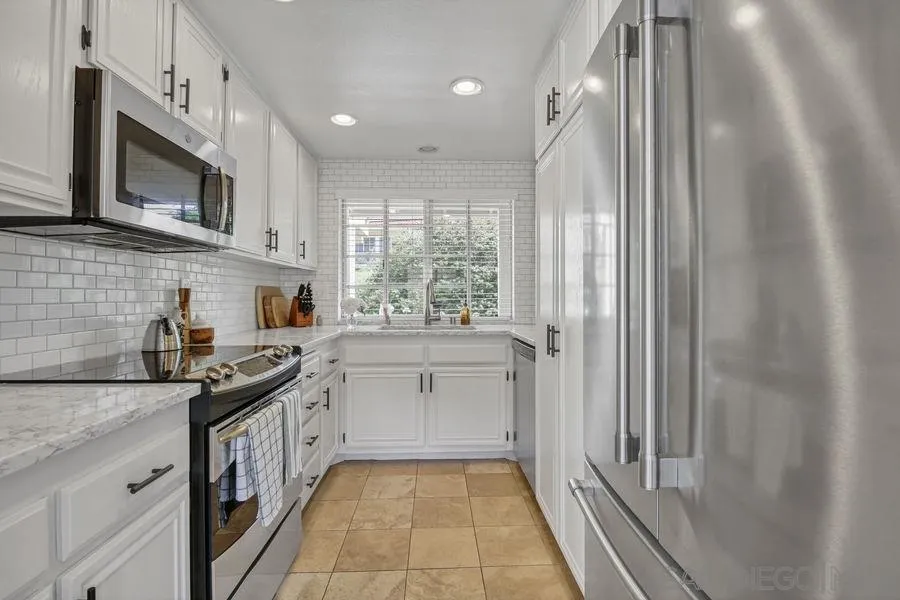 1758 Edgefield Lane Encinitas, CA 92024 - Photo 7 of 25 a kitchen with stainless steel appliances granite countertop white cabinets a sink and a oven