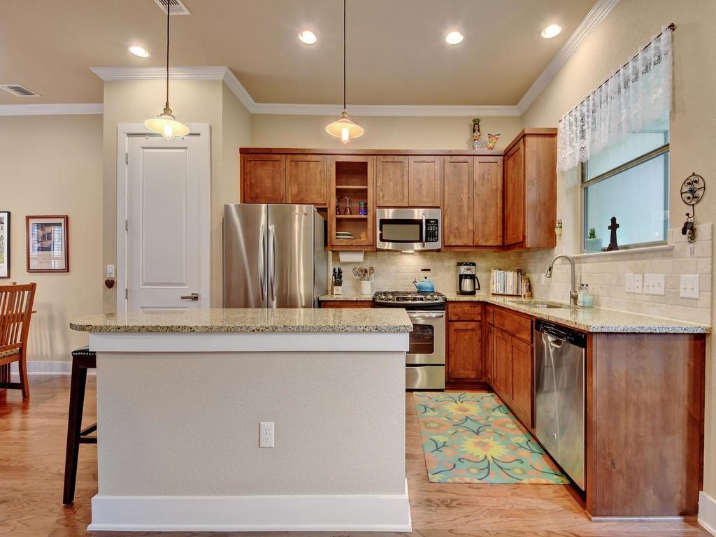 4545 Mattie Street Austin, TX 78723 - Photo 8 of 28 a kitchen with kitchen island granite countertop a sink stainless steel appliances and cabinets