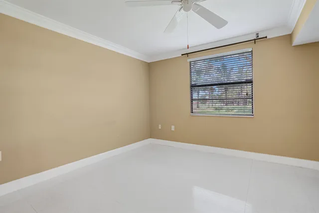 an empty room with a ceiling fan and a window