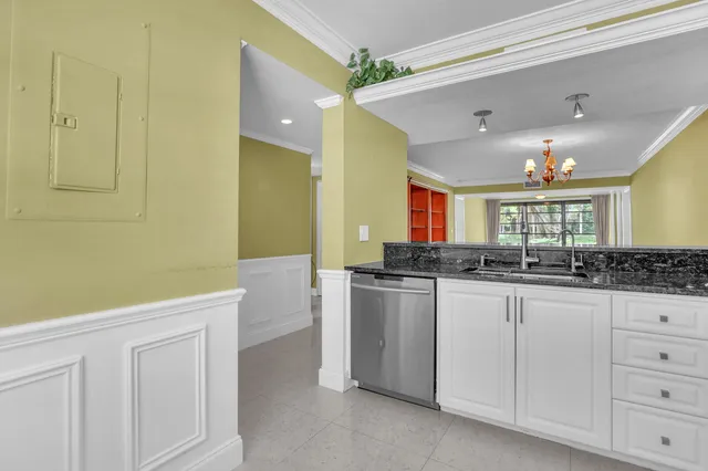a kitchen with white cabinets and sink