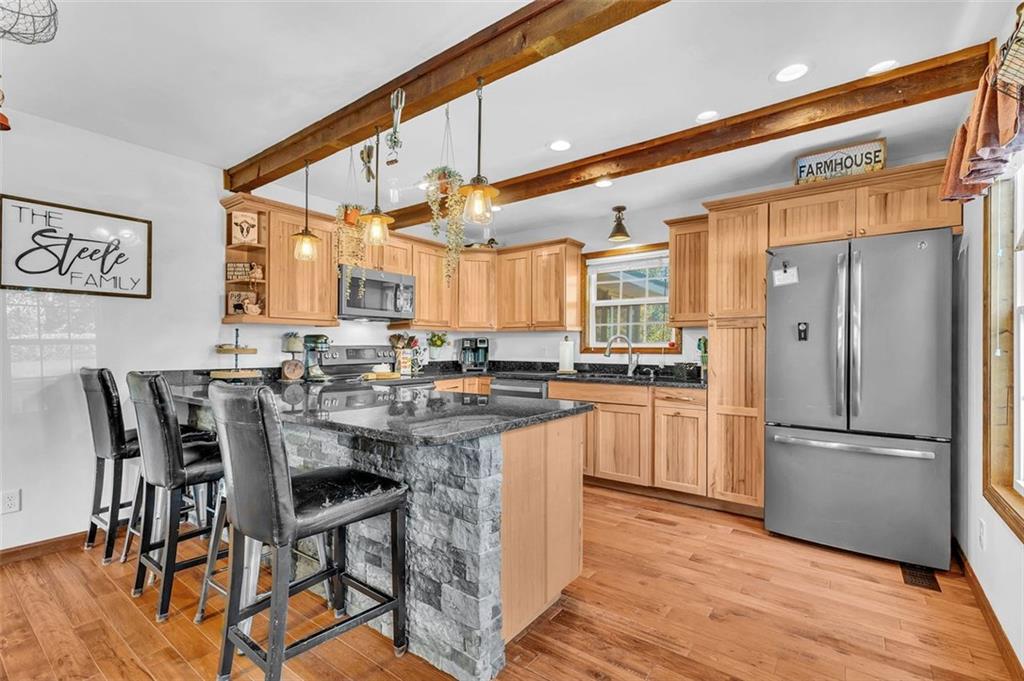 340 Tom Bell Road Milner, GA 30257 - Photo 12 of 34 a kitchen with stainless steel appliances a refrigerator a stove a sink and white cabinets with wooden floor