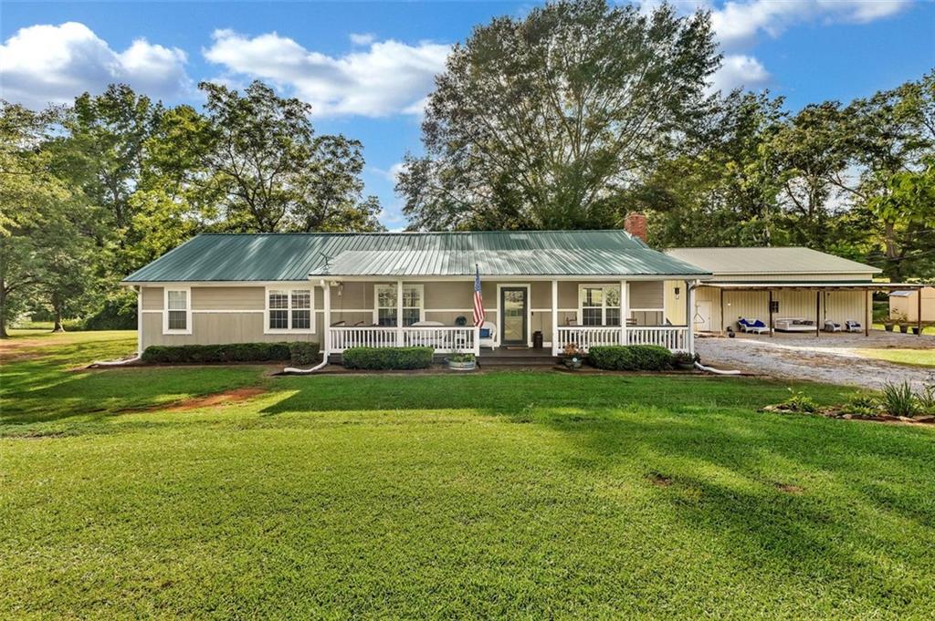 340 Tom Bell Road Milner, GA 30257 - Photo 2 of 34 a front view of a house with a yard and trees