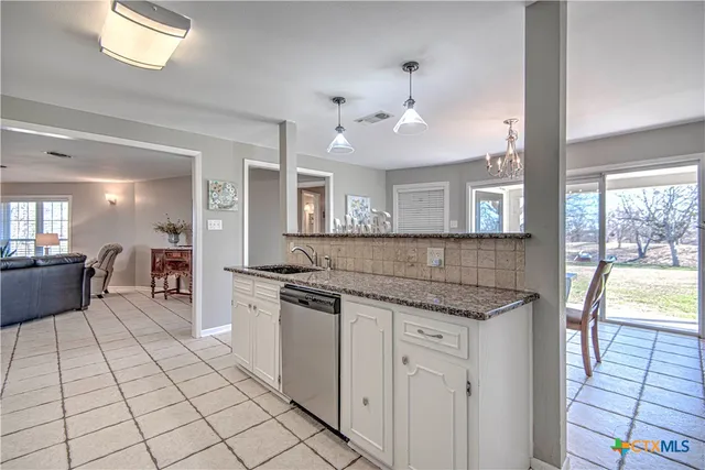 a kitchen with stainless steel appliances granite countertop a stove and cabinets