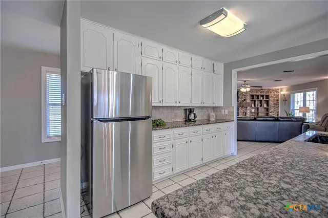a kitchen with stainless steel appliances a refrigerator sink and cabinets
