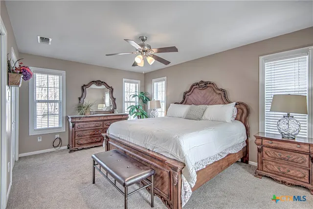 a bedroom with a bed a chandelier and dresser