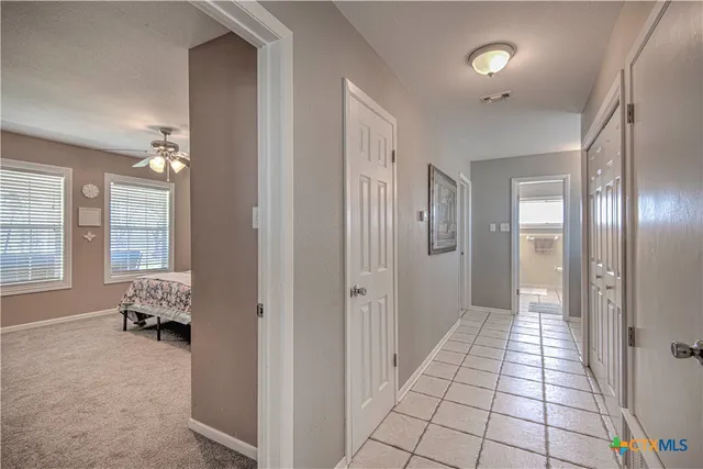 a view of hallway with windows and chandelier