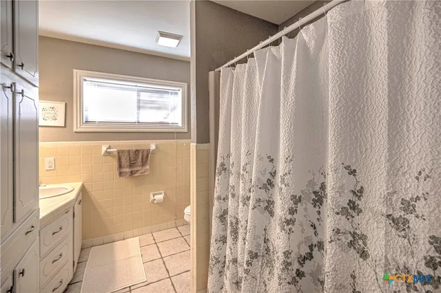 a bathroom with a granite countertop sink a mirror and a shower