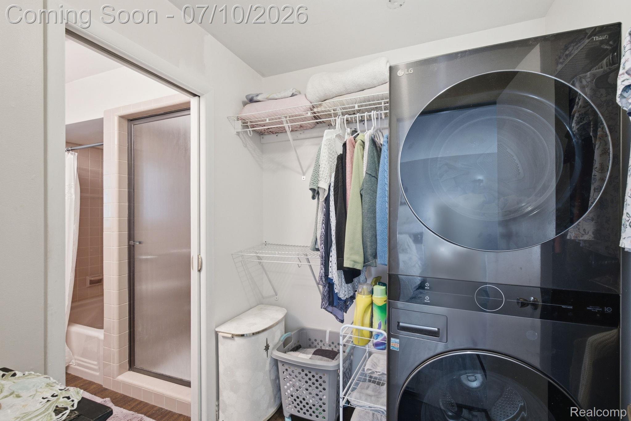 1501 River Road, Unit 301 St. Clair, MI 48079 - Photo 21 of 32 Dedicated laundry area featuring a stacked washer and dryer, wire shelving, and hanging rod