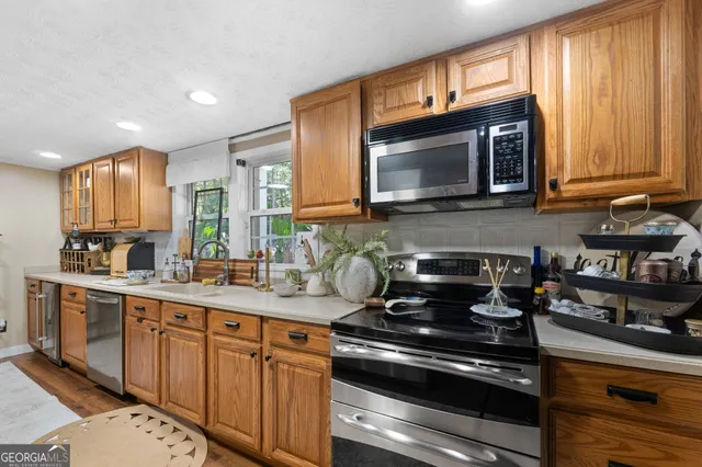 a kitchen with stainless steel appliances granite countertop a stove a sink and a refrigerator