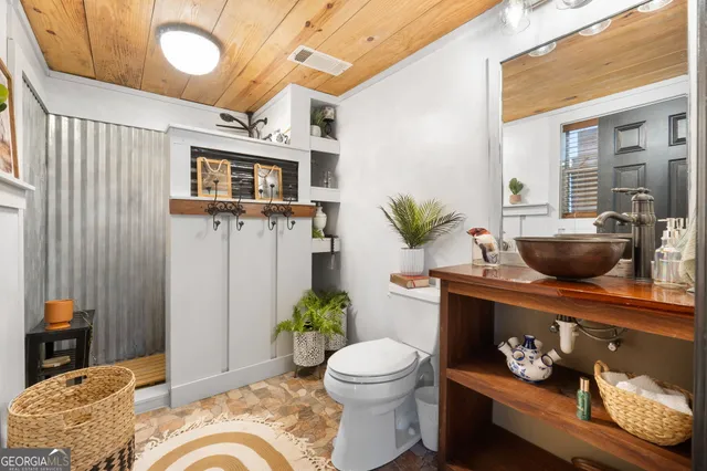 a bathroom with a granite countertop sink and a toilet