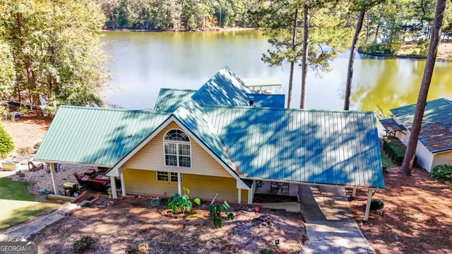 a small pool with lawn chairs under an umbrella
