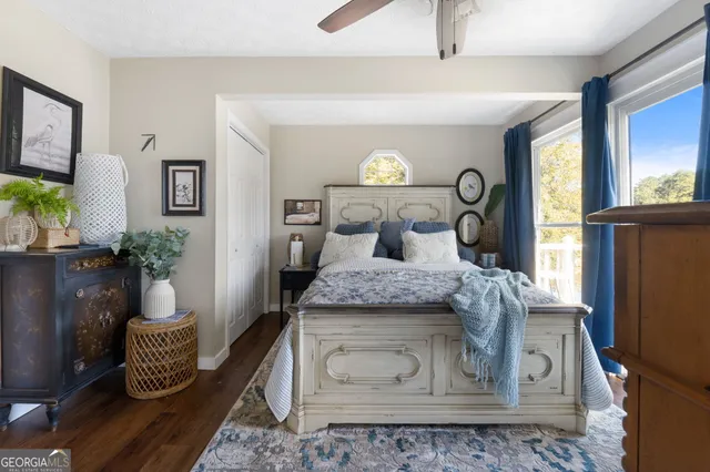 a bedroom with a bed a flat tv screen and dresser