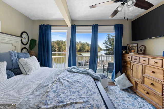 a bedroom with a large bed and a flat tv screen on dresser