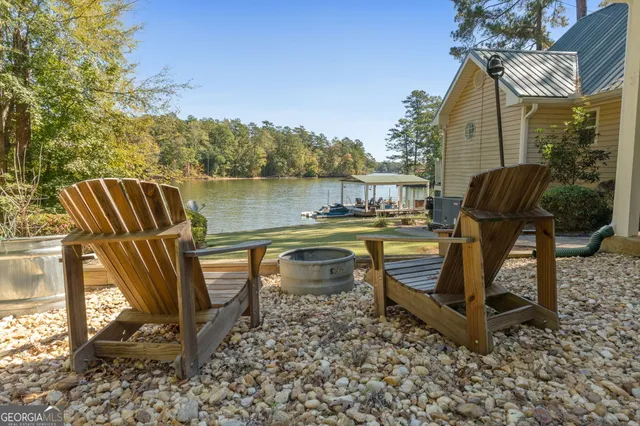 a view of a lake with a table and chairs under an umbrella