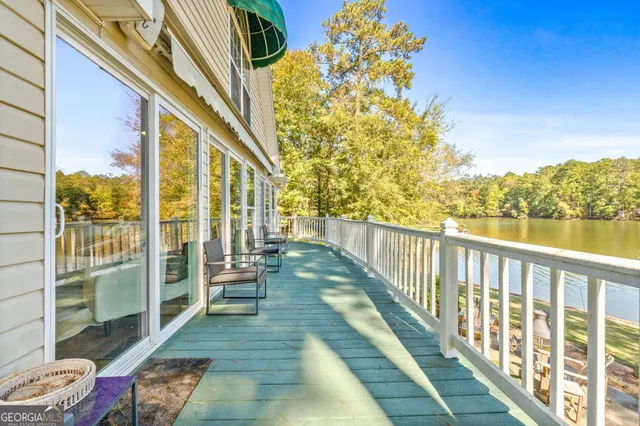 a balcony with chairs and lake view