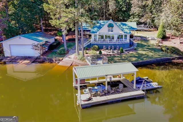 a view of a lake with a house swimming pool and outdoor seating