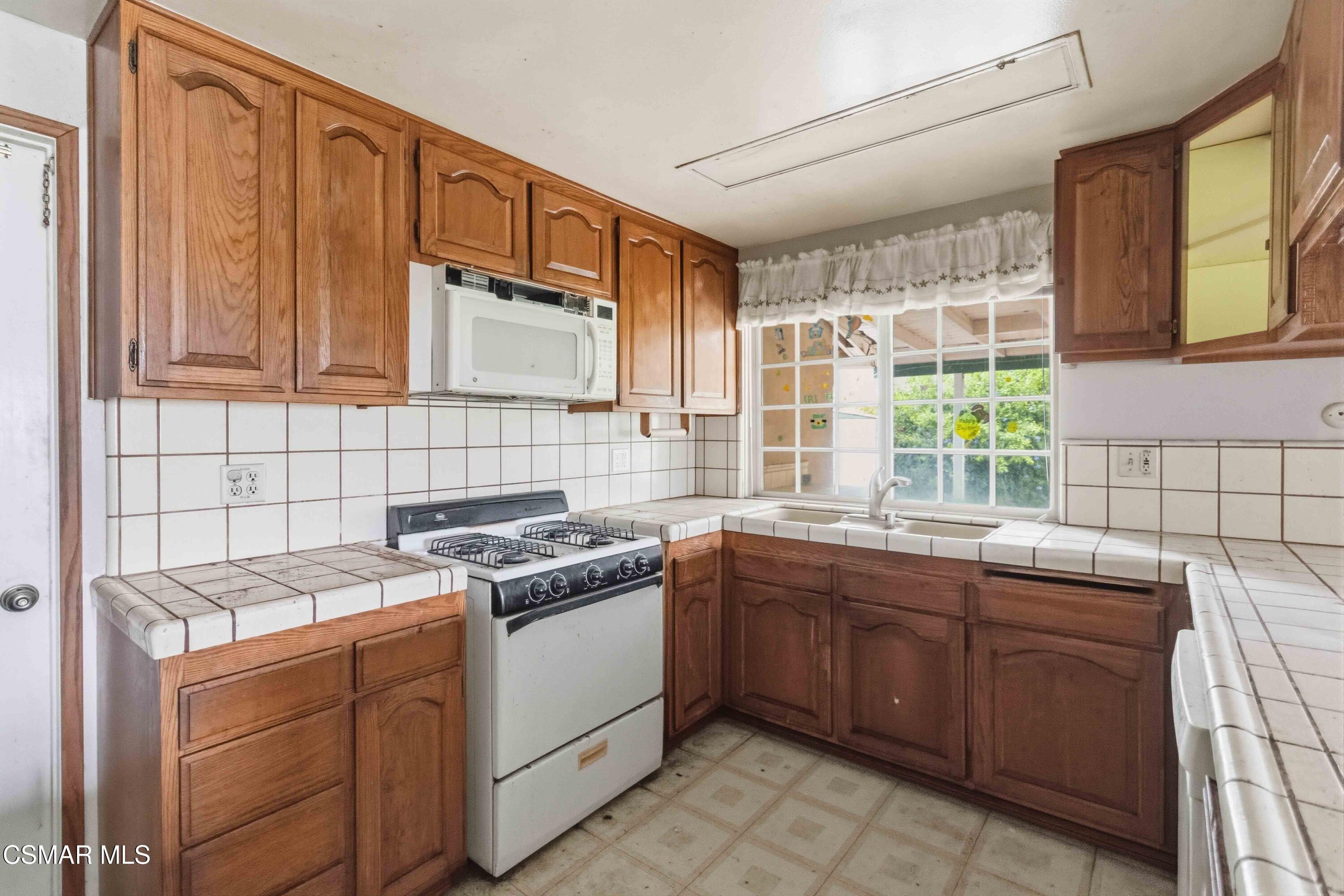 2077 Sebring Court Simi Valley, CA 93065 - Photo 5 of 20 a kitchen with a stove sink and cabinets