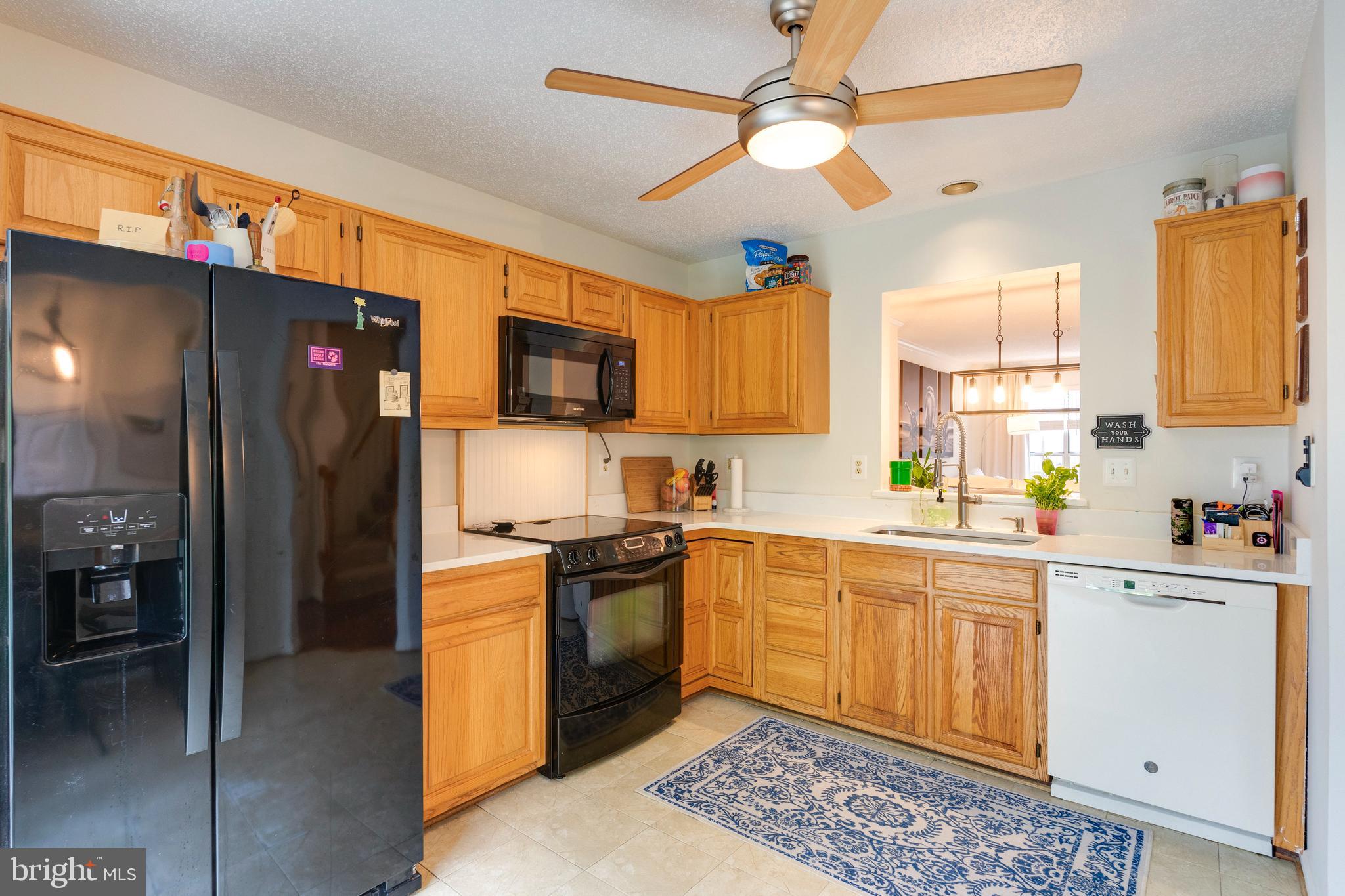 2303 Massanutten Drive Silver Spring, MD 20906 - Photo 3 of 24 a kitchen with stainless steel appliances granite countertop a refrigerator a stove a sink a dining table and chairs with wooden floor