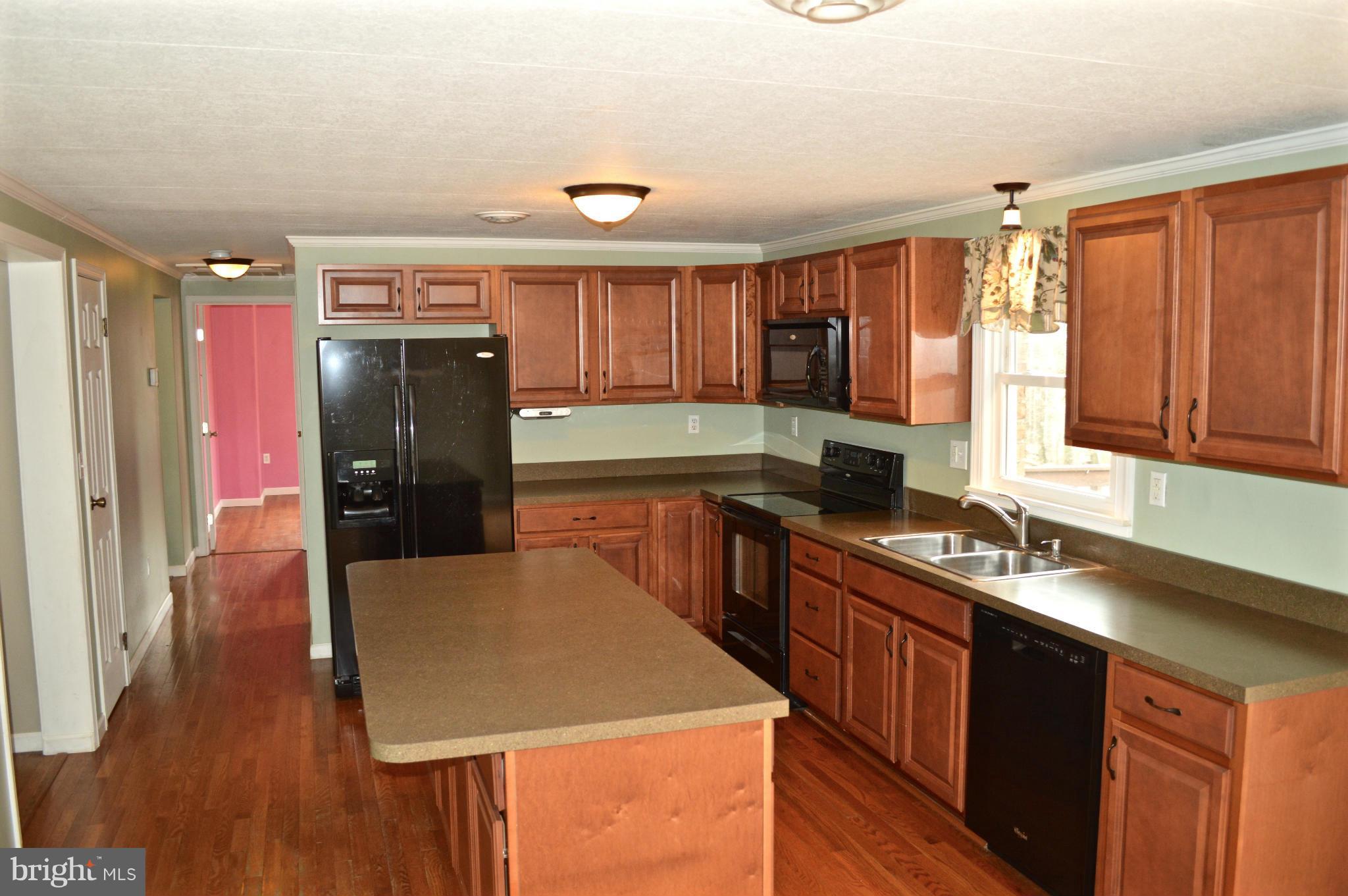 11812 Warner Road Keymar, MD 21757 - Photo 4 of 25 a kitchen with a refrigerator a sink and wooden cabinets