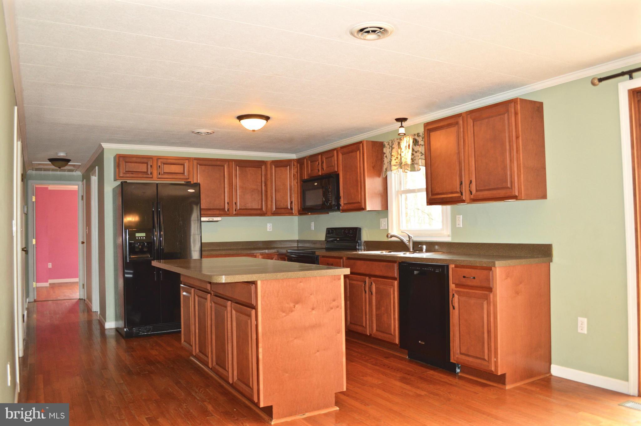 11812 Warner Road Keymar, MD 21757 - Photo 6 of 25 a kitchen with stainless steel appliances granite countertop a refrigerator a sink dishwasher a stove with wooden cabinets and floor