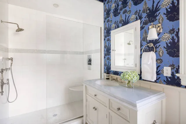 a bathroom with a granite countertop sink a mirror and shower
