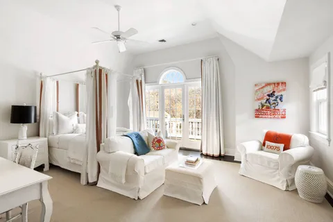 a spacious bedroom with furniture and a large window