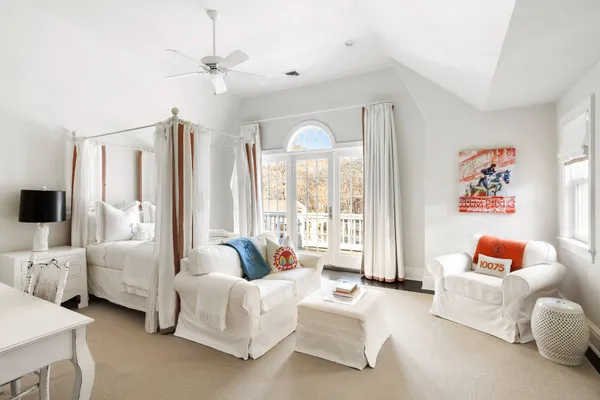 a spacious bedroom with furniture and a large window