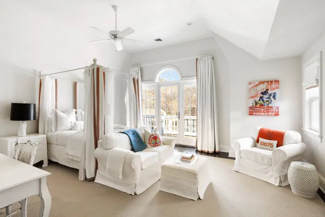 a spacious bedroom with furniture and a large window