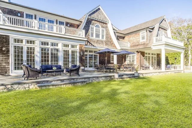 a house view with swimming pool and chairs
