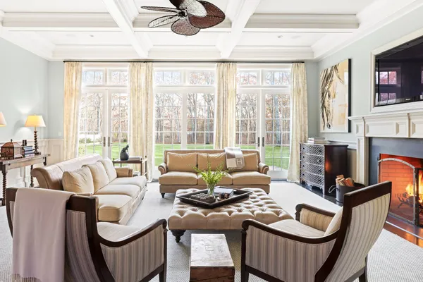 a living room with furniture a flat screen tv and a large window