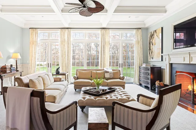 a living room with furniture a flat screen tv and a large window