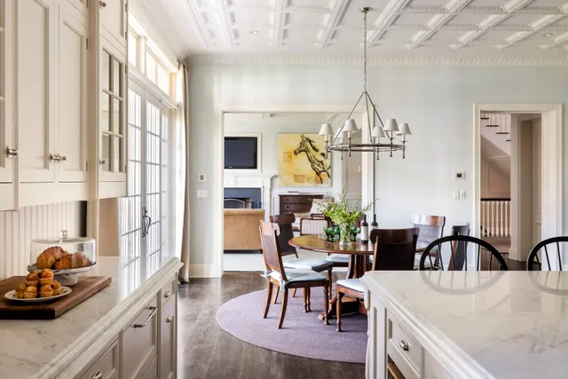 a view of a dining room and livingroom with furniture wooden floor a chandelier
