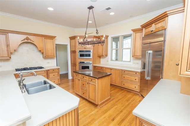 a kitchen with stainless steel appliances granite countertop a stove a sink and a refrigerator