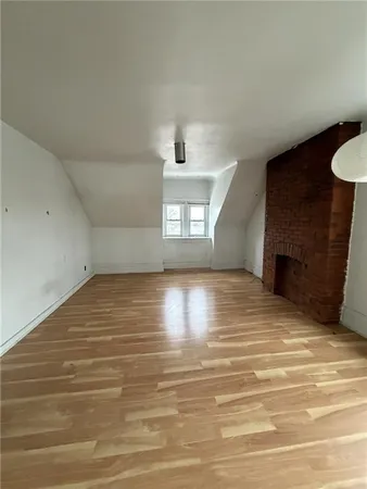 a view of empty room with a fireplace and window