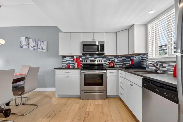 a kitchen with kitchen island granite countertop a sink cabinets and stainless steel appliances