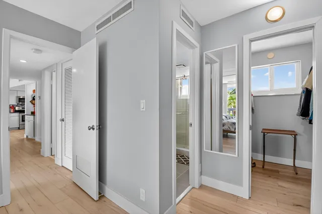 a view of a hallway with wooden floor and living room