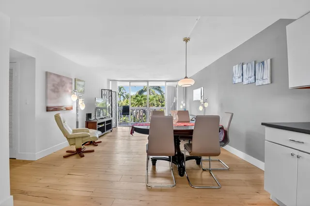a dining room with furniture a chandelier and wooden floor