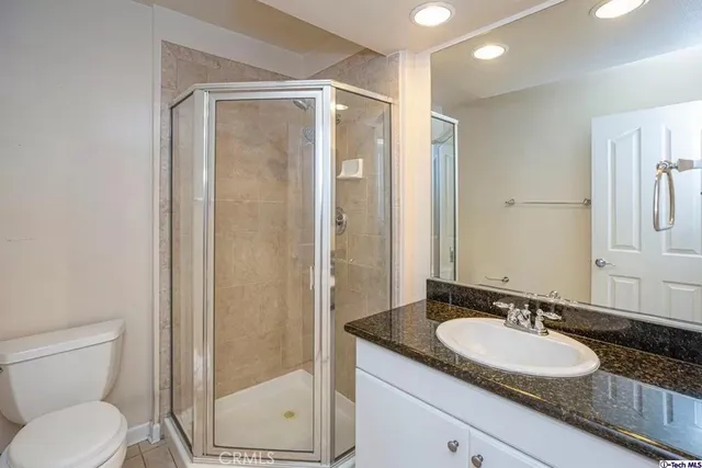 a bathroom with a granite countertop sink toilet and shower