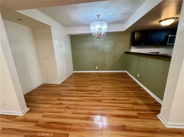 a view of a livingroom with kitchen and an empty room