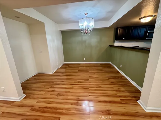 a view of a livingroom with kitchen and an empty room