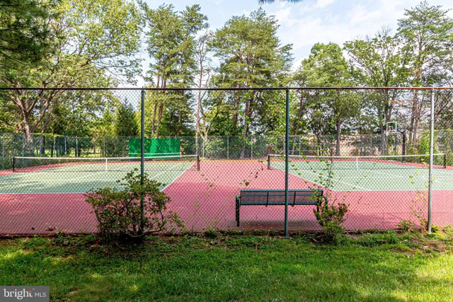 a backyard of a house with table and chairs under an umbrella