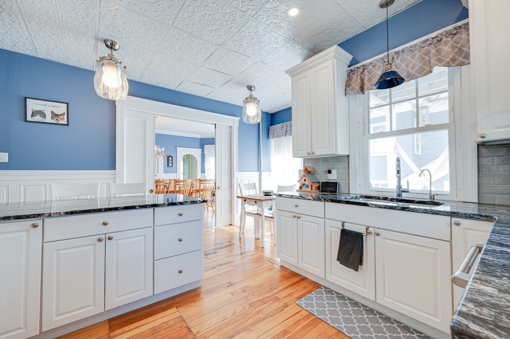 23 Germain Street Worcester, MA 01602 - Photo 11 of 42 a kitchen with granite countertop white cabinets white appliances a sink and a window