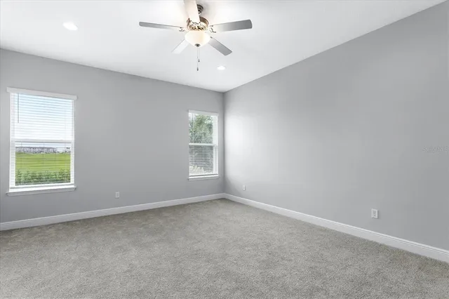 an empty room with a ceiling fan and a bathroom
