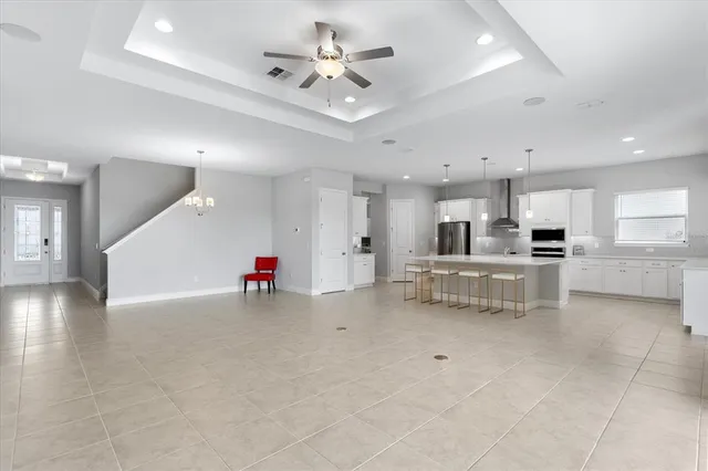 a kitchen with refrigerator and chairs