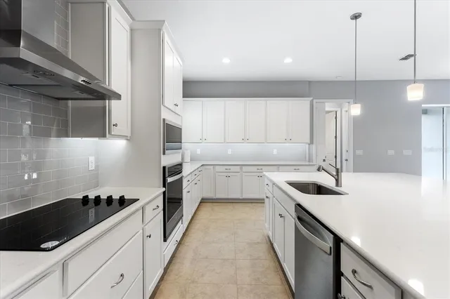 a kitchen with stainless steel appliances a refrigerator sink and cabinets